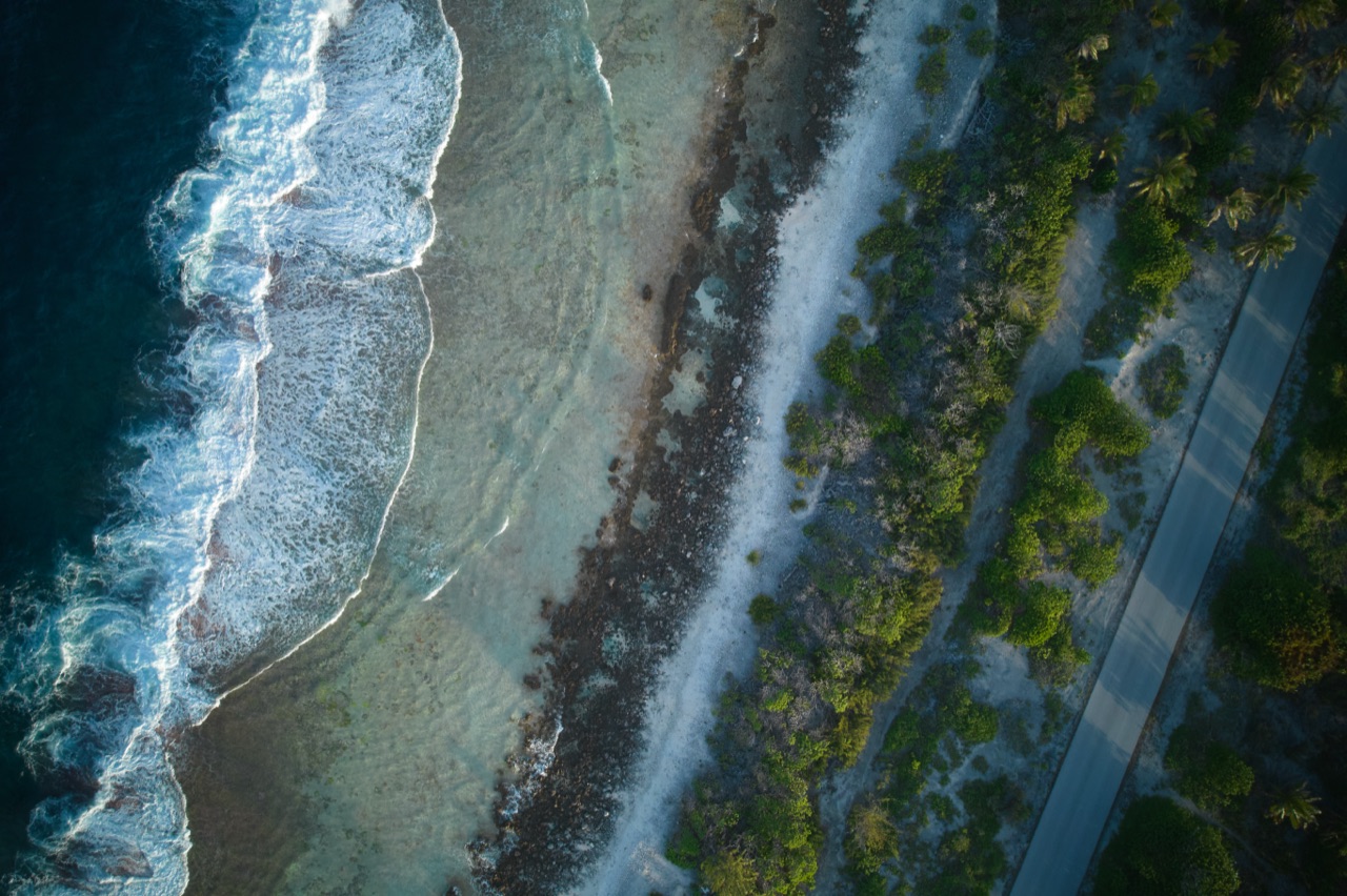 Aerial view of a reef flat, coastline, and road